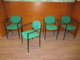 quatre chaises vertes dans un coin de la pièce