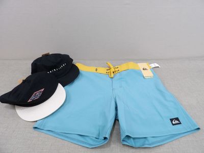 two hats and a pair of shorts are laying on a bed