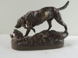 statue représentant un chien et un oiseau sur un rocher