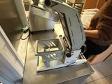 une femme debout dans une cuisine, à côté d'un appareil