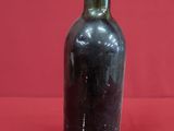 a bottle of wine that is sitting on a red surface