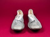 pair of silver shoes on a red background