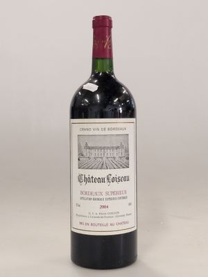 a bottle of red wine sitting on top of a white table