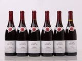 six bouteilles de vin rouge sont alignées sur une table