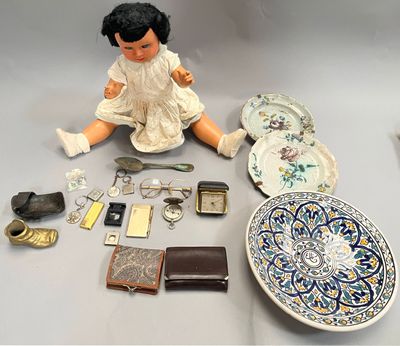 a doll that is sitting on the ground next to a plate