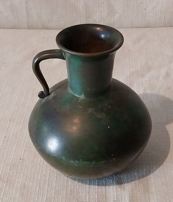 un vase vert posé sur une table