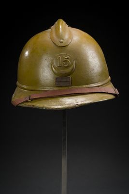 an old helmet on a metal stand with a black background