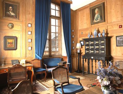 un salon avec beaucoup de meubles et de tableaux aux murs