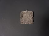 un petit sac à main argenté posé sur une table noire