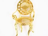 chaise miniature plaquée or sur fond blanc, avec un fond blanc