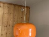an orange lamp hanging from the ceiling in a room