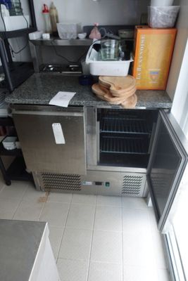 une petite cuisine équipée d'un réfrigérateur, d'un évier et d'un micro-ondes