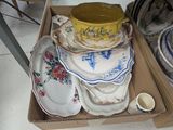 many plates and bowls in a box on the floor