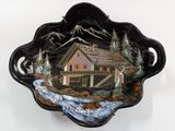 a black bowl with a picture of a cabin on it