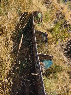 a boat that is sitting in the grass on the side of a hill