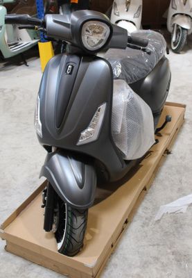 un scooter posé sur un carton dans un garage