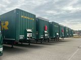 beaucoup de camions verts garés sur un parking