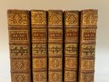 un ensemble de cinq livres anciens avec couvertures en cuir doré et brun