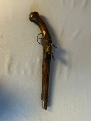 un vieux pistolet posé sur une surface blanche