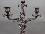 a silver plated candelab with three candles on a stand