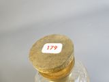 une bouteille en verre avec un bouchon doré posée sur une table