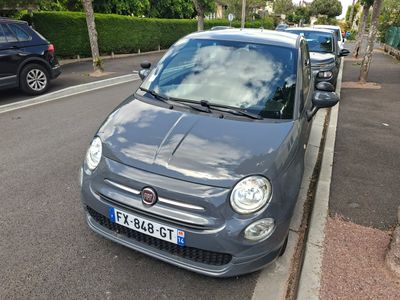 une petite voiture grise garée sur le bord de la route