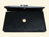 a black purse that has a gold button on it