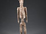 une statue représentant un personnage humain avec un crâne sur la tête