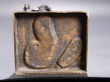 a small bronze sculpture of a woman in a box