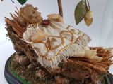 a figurine of a baby in a basket on a tree stump