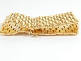 gold plated bracelet with a woven design on a white background
