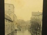 une vieille photo d'une rivière traversant une ville