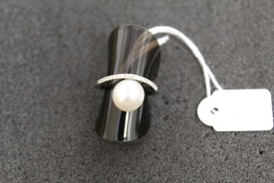 une bague ornée d'une perle et d'une petite étiquette