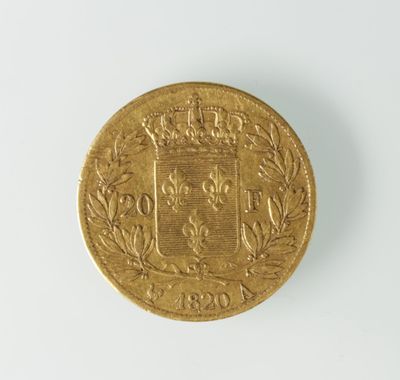 gros plan d'une pièce d'or sur une surface blanche