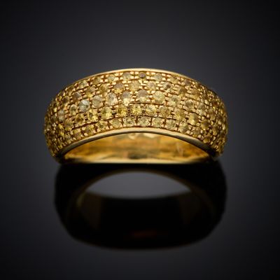 a gold ring with yellow diamonds on a black surface