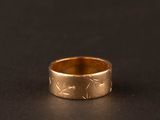 gros plan d'une bague en or sur une surface noire