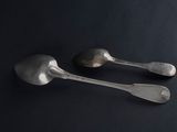 two spoons and a fork on a black surface