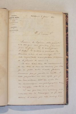 un livre ouvert avec une écriture dessus, posé sur une table