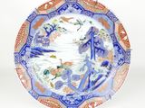 a blue and orange plate with birds and flowers on it
