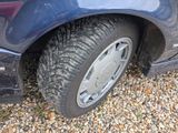 a close up of a car ' s tire on a gravel road