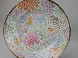 a close up of a plate with flowers on it on a stand