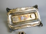 a silver tray with a candle and a candle holder