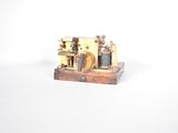 une petite maquette de machine à vapeur posée sur un socle en bois