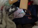a pile of clothes and a box on a bed
