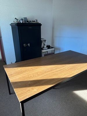 une table en bois dans une pièce, avec une armoire en arrière-plan