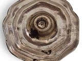 a silver plate with a hole in it on a white surface