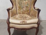 une vieille chaise dont l'assise est recouverte d'un tissu à motifs floraux