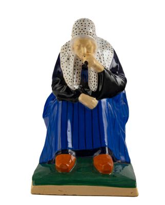 une figurine représentant une femme assise sur un banc