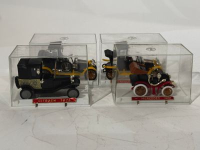 deux petites voitures dans une boîte transparente posée sur une surface blanche
