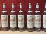 six bouteilles de vin sont alignées sur une table